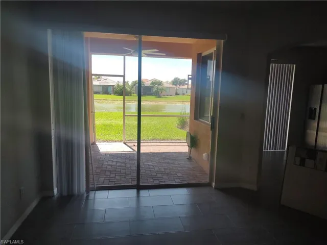 Doorway to outside featuring a water view, tile patterned flooring, and a residential view