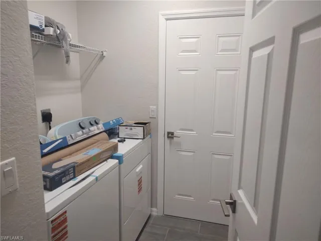 Laundry area with a textured wall and washing machine and dryer