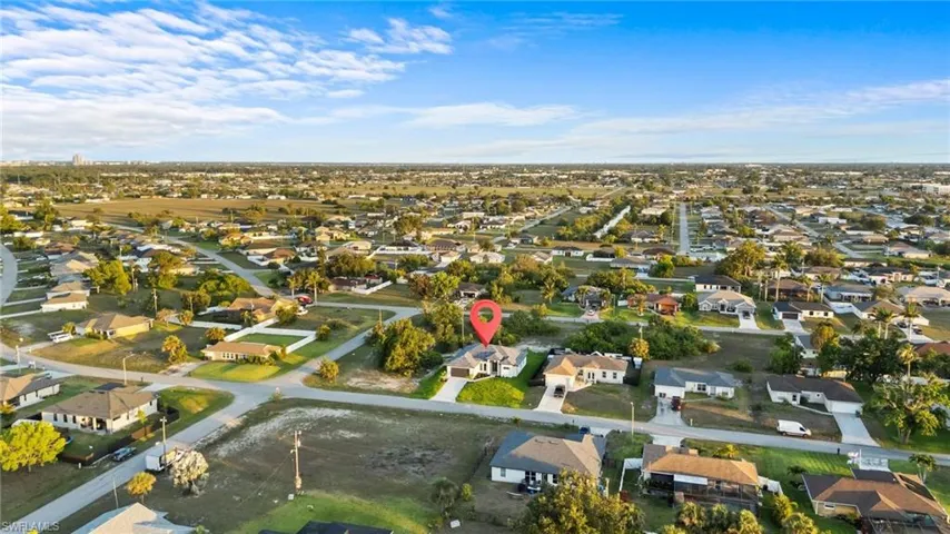 Aerial view of property and surrounding area with nearby suburban area