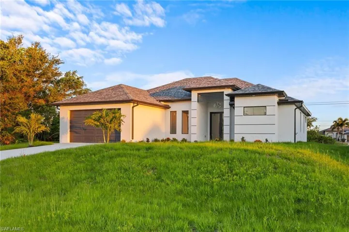 Prairie-style home featuring stucco siding, driveway, and an attached garage