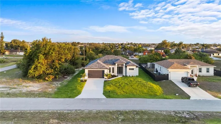 View of front facade with concrete driveway, a front yard, and a residential view