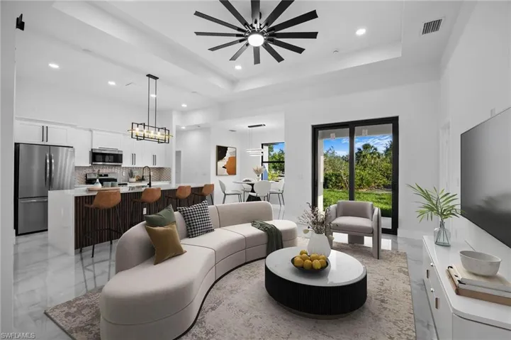 Virtual Staged Living area with recessed lighting, a tray ceiling, light marble finish floors, a chandelier, and a towering ceiling