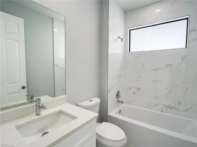 Bathroom with toilet, vanity, and shower / bathtub combination