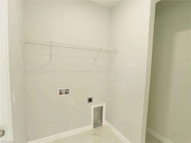 Laundry room with baseboards, laundry area, hookup for an electric dryer, marble finish floor, and hookup for a washing machine