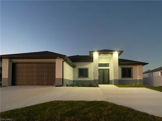 Prairie-style home with an attached garage, driveway, and stucco siding