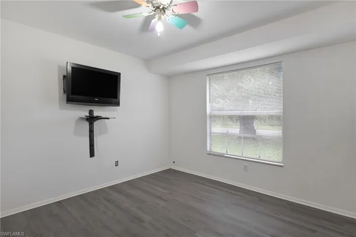 Unfurnished room featuring dark hardwood / wood-style flooring and ceiling fan