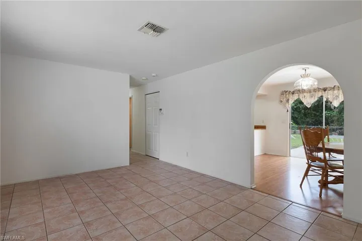 Tiled spare room with a chandelier