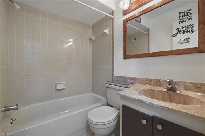 Full bathroom with vanity, tiled shower / bath, and toilet
