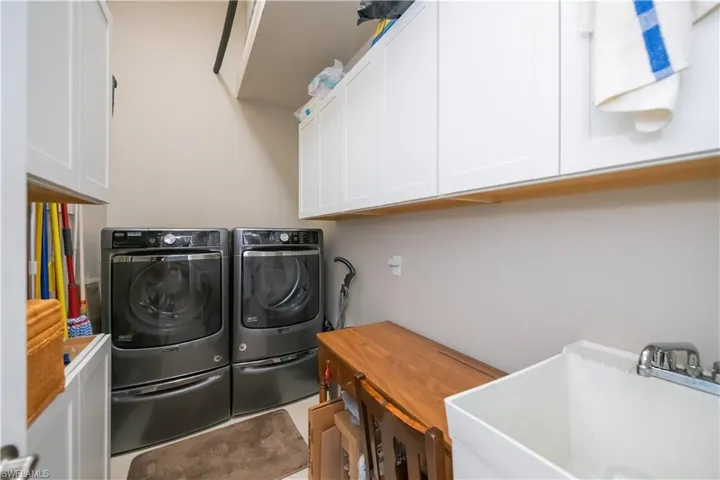 Large laundry room with high end washer and dryer, utility sink and plenty of storage