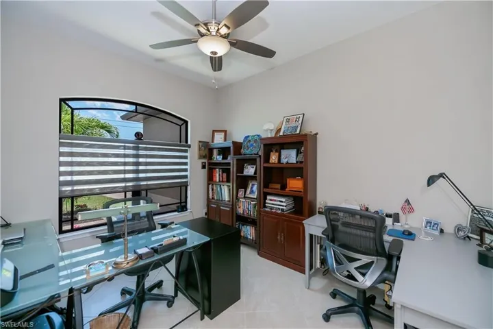 Large office area/den featuring a ceiling fan and light tile patterned floors