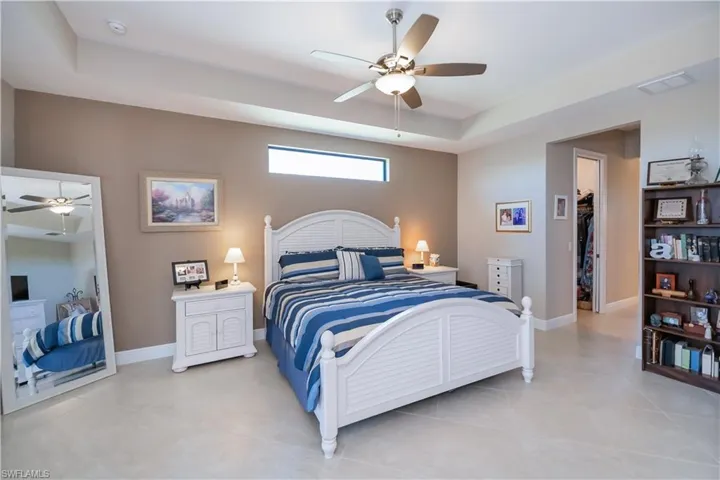 Massive primary bedroom with lots of natural light, tray ceiling with ceiling fan