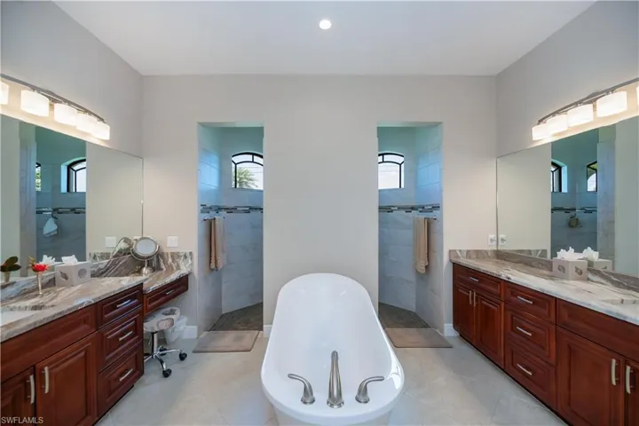 Primary bathroom features plenty of natural light, a walk in shower and a huge soaking tub