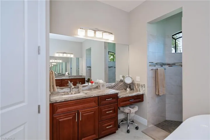 Primary bathroom features separate vanities and sinks