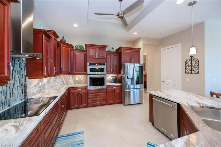 Plenty of room to cook in this modern kitchen with granite countertops, decorative backsplash and a ceiling fan