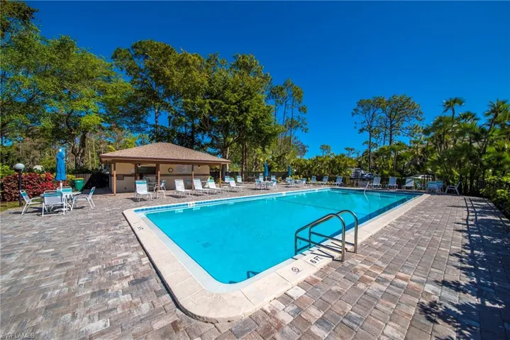 Rectangular swimming pool with integrated steps, surrounded by extensive paver decking