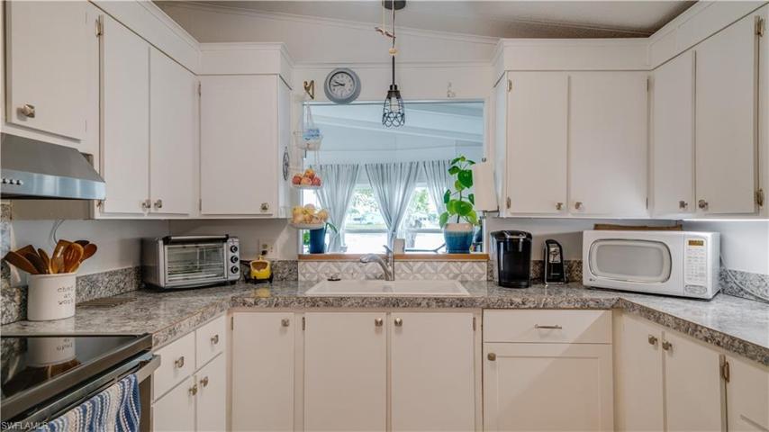 This remodeled kitchen is sure to impress. The picturesque window with a lake view; an added bonus.