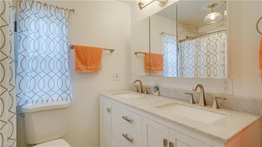 What's behind curtain number 1? A large porcelain walk-in shower. The new owners will take advantage of dual sinks placed within a marble counter top.
