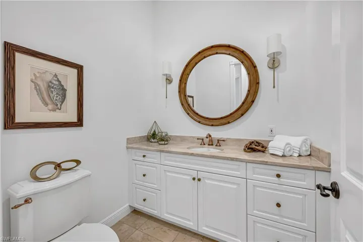 Bathroom with toilet, vanity, baseboards, and tile patterned flooring
