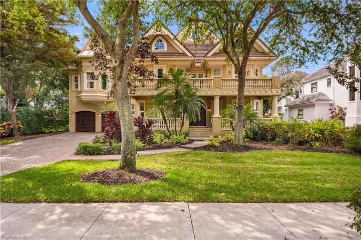 View of front of house featuring a balcony, stucco siding, decorative driveway, and a front lawn