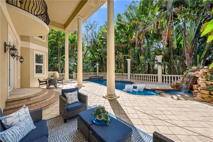 View of patio with an outdoor living space and a pool with connected hot tub