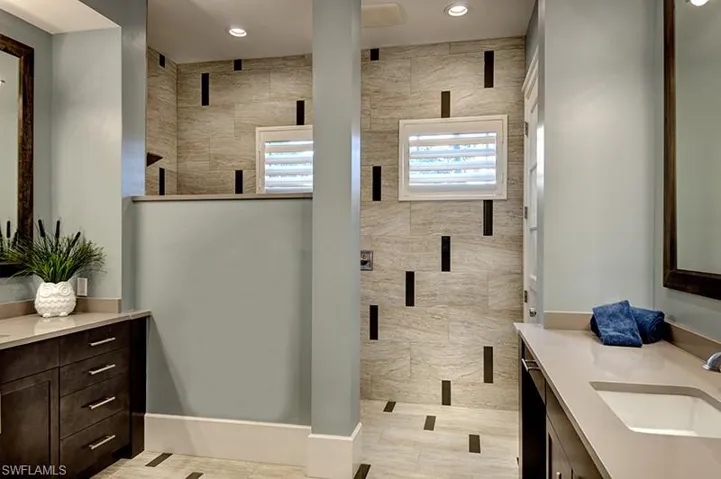 Bathroom featuring a tile shower and vanity