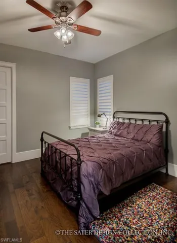 Bedroom with dark wood-type flooring, a ceiling fan, and baseboards
