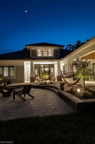 Back of house at twilight featuring a patio