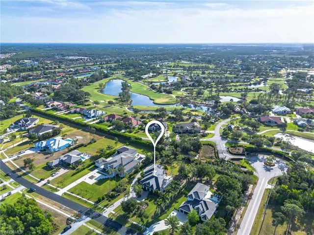 Drone / aerial view with golf course view, a water view, and a residential view