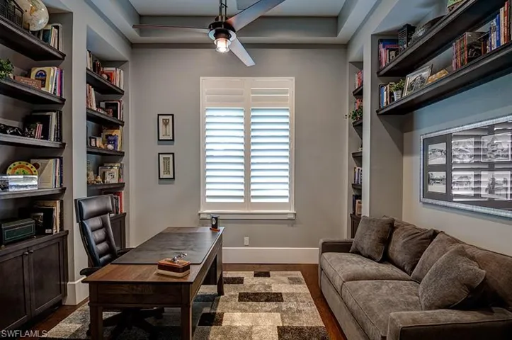 Office area featuring built in features, dark hardwood / wood-style floors, and ceiling fan