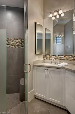 Bathroom featuring vanity, a shower with door, and tile patterned flooring