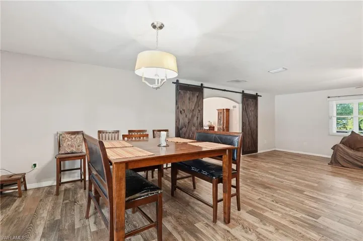 Dining space featuring a barn door and light wood finished floors