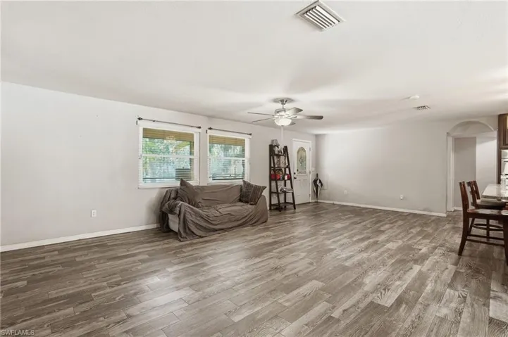 Sitting room with wood finished floors, ceiling fan, and arched walkways