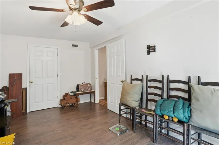 Sitting room with dark wood-style floors and ceiling fan