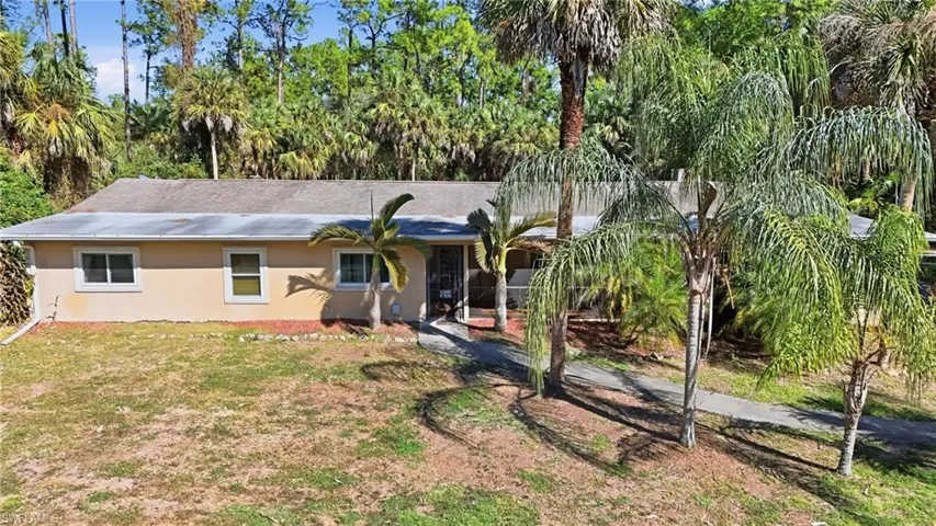 View of front of property featuring stucco siding and a front lawn