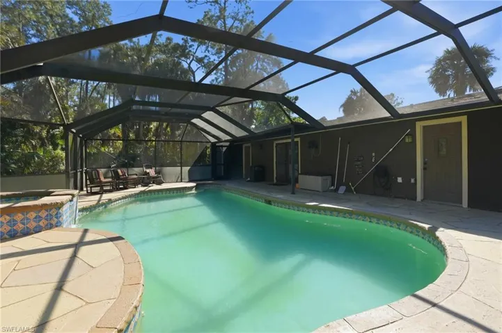 Combined pool / hot tub with a lanai, a patio area, and a sunroom