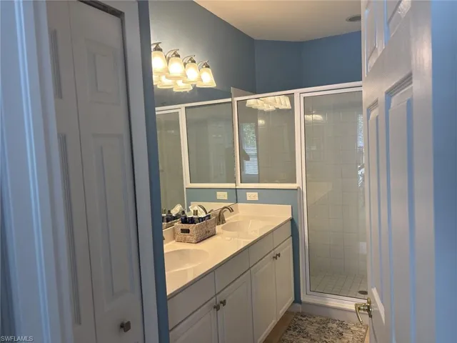 Bathroom with double vanity and a stall shower