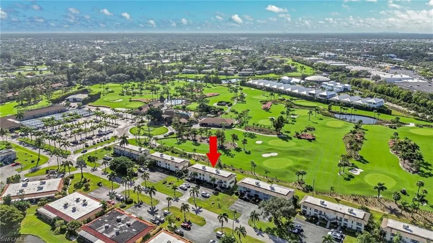 Aerial view of residential area with a nearby body of water and a golf club
