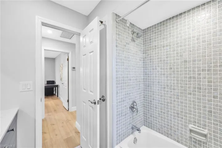 Full bath featuring vanity, shower / washtub combination, and light wood finished floors