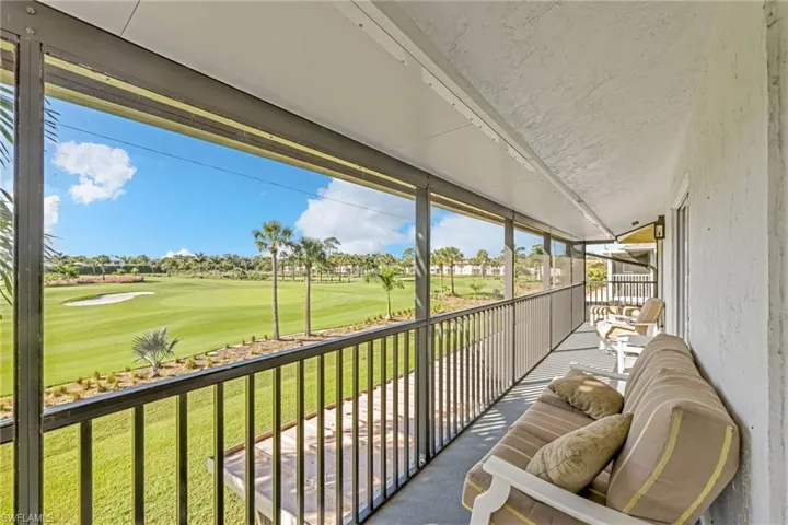 Balcony featuring view of golf course and a sunroom