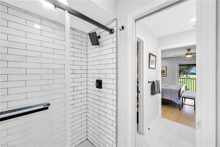 Bathroom featuring a shower stall, ensuite bath, ceiling fan, and light marble finish flooring