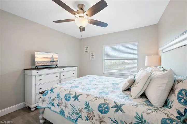 Bedroom with ceiling fan and dark wood finished floors