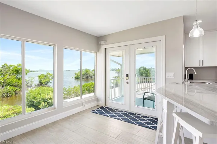 Doorway to outside featuring french doors, a water view, and wood finished floors