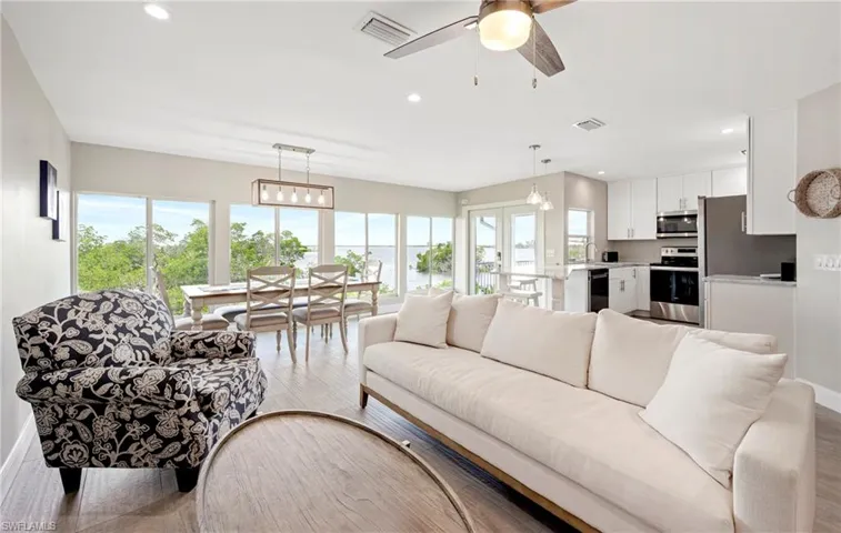 Living area with recessed lighting, a ceiling fan, and light wood-style floors