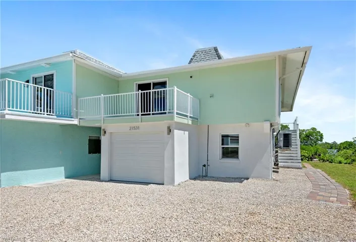 Back of property with a garage and stucco siding