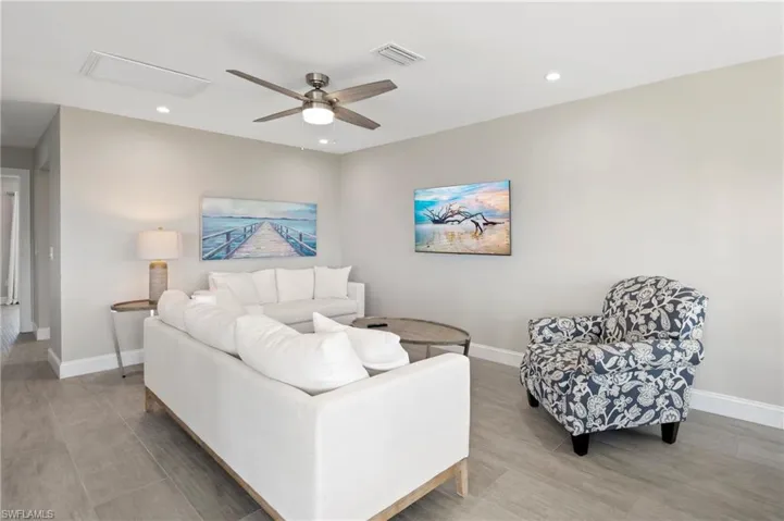 Living area with a ceiling fan, recessed lighting, and light wood-style floors