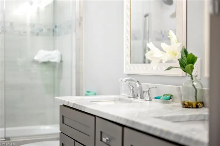 Bathroom featuring vanity and enclosed tub / shower combo