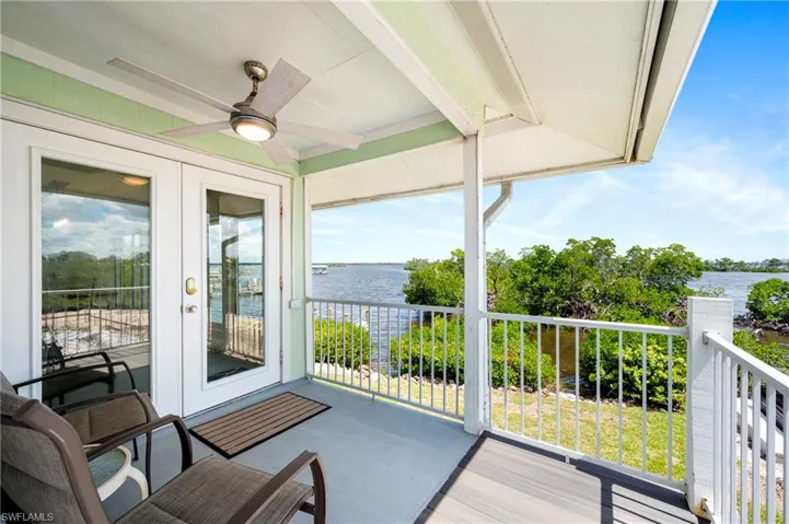 Balcony featuring ceiling fan, a water view, french doors, and a sunroom