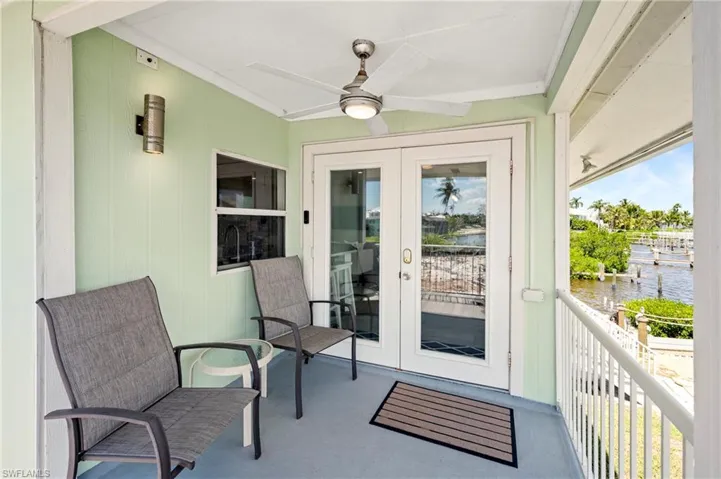 Entrance to property with a ceiling fan and a water view