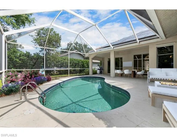 Virtually Staged View of pool featuring screen enclosure and a patio area