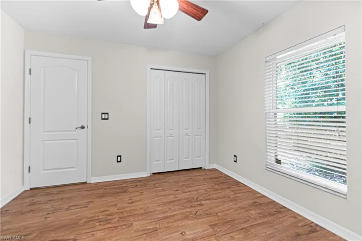 Unfurnished bedroom with hardwood / wood-style flooring, a closet, and ceiling fan